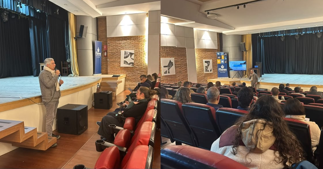 Jornada sobre seguridad y salud laboral en una sala de teatro, con un expositor frente al público